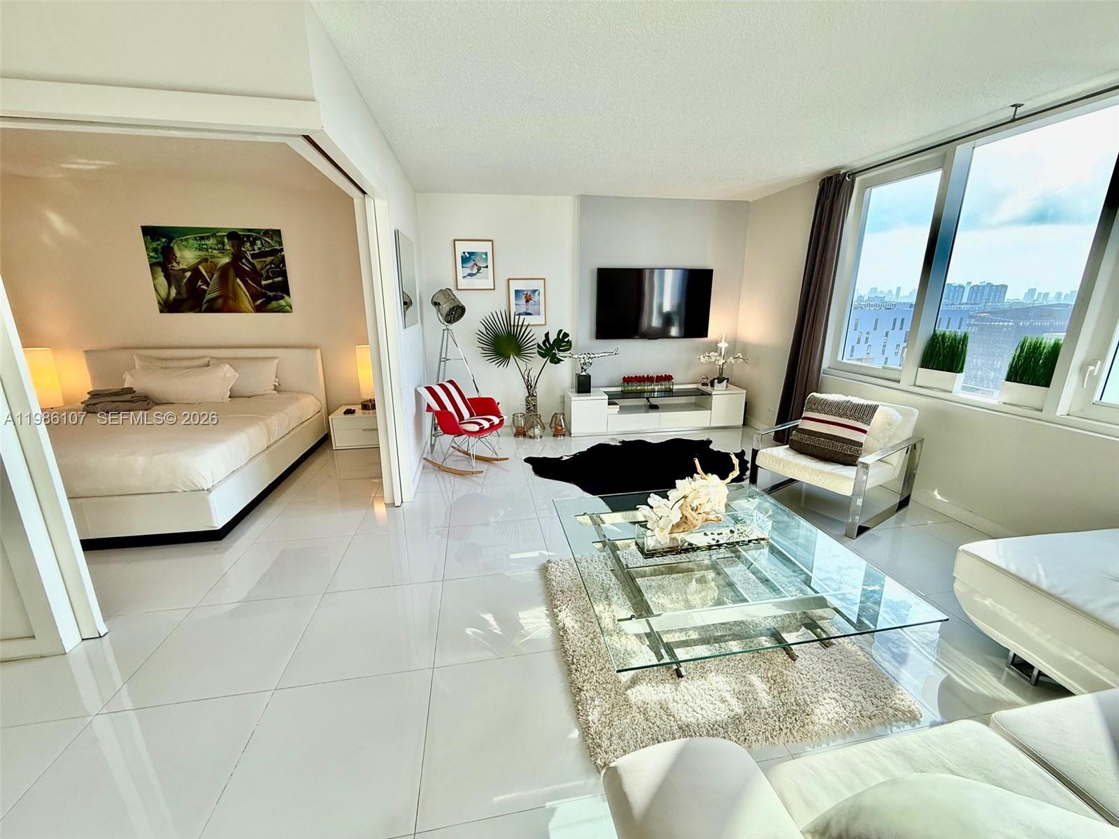 A bright living room with white tile floors connects to an adjacent bedroom — 2301 Collins Ave # 931, Miami Beach FL 33139, MIAMI BEACH, FL