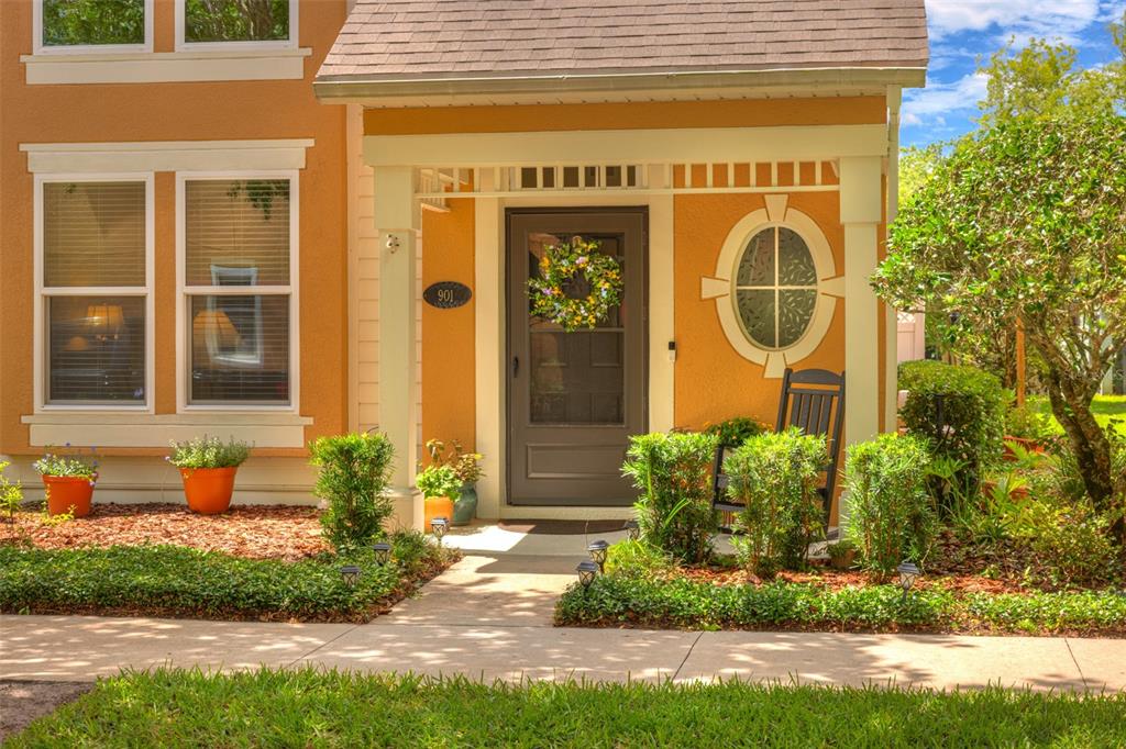 A front view of a house exterior featuring a covered porch, front door, and landscaping — 901 WYNBROOK LANE, DELAND, FL