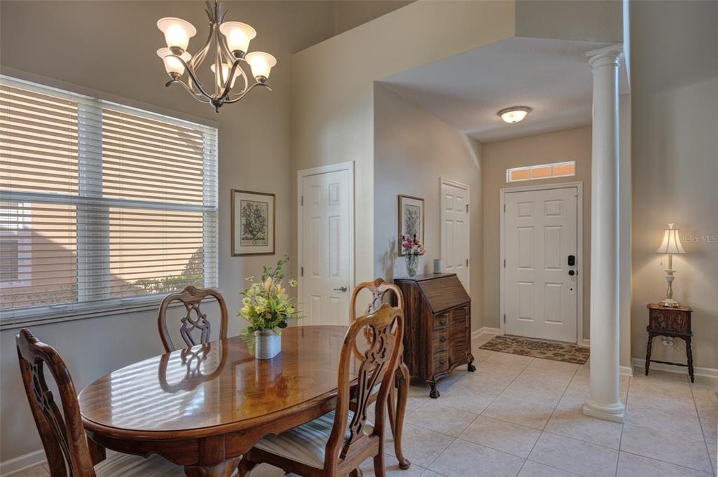 A dining area with a wooden table and chairs sits adjacent to a tiled entryway — 901 WYNBROOK LANE, DELAND, FL