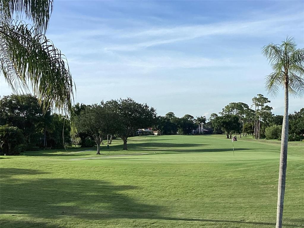 A view of a green golf course fairway with trees and a flagstick — 6211 TIMBER LAKE DRIVE UNIT B4, SARASOTA, FL