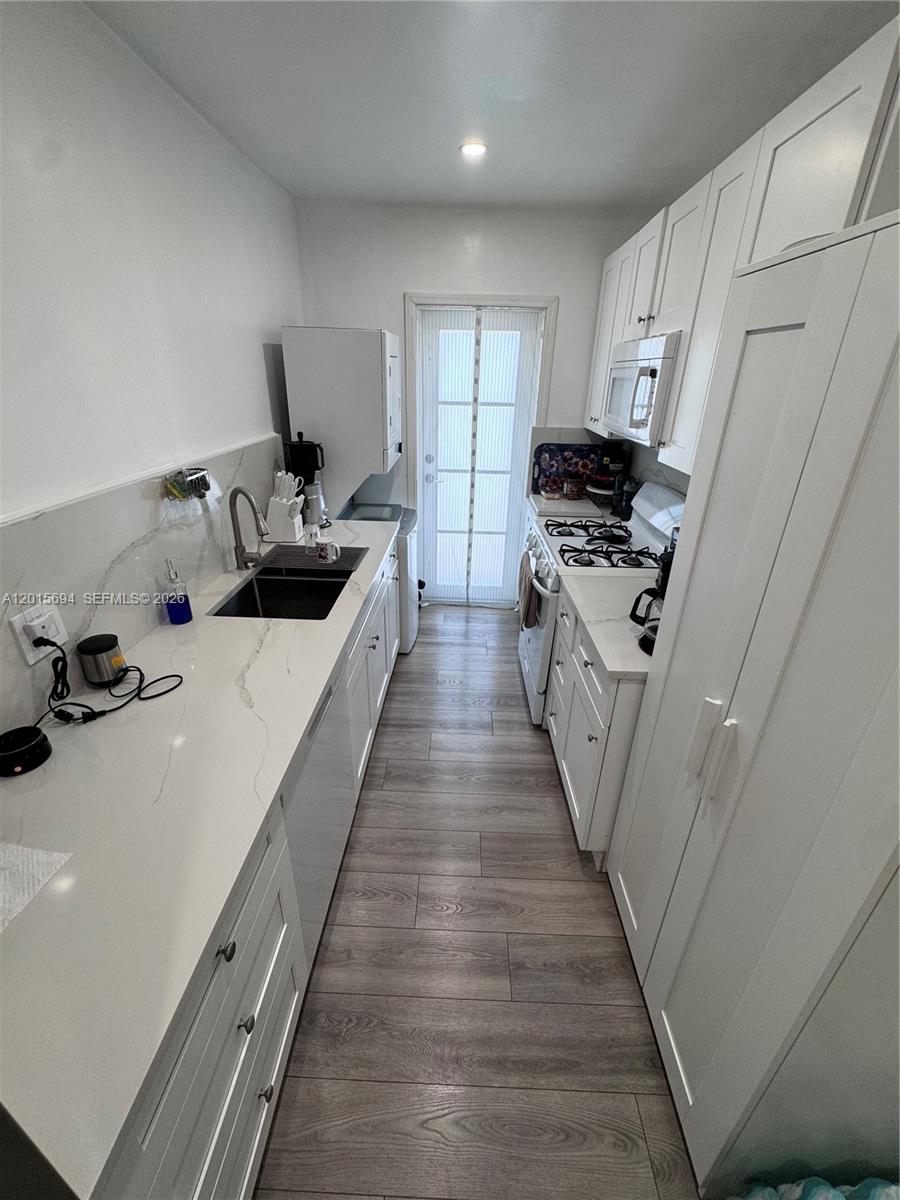 A swimming pool overlooks a wide canal with several docked boats and palm trees — 8550 Byron Ave # 2G, Miami Beach FL 33141, MIAMI BEACH, FL