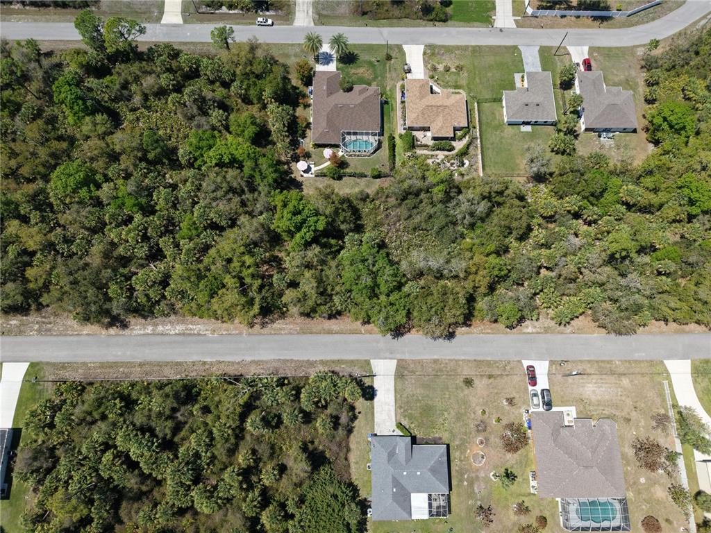 An aerial view shows several houses with swimming pools surrounded by dense wooded areas — MCALLISTER LANE, NORTH PORT, FL