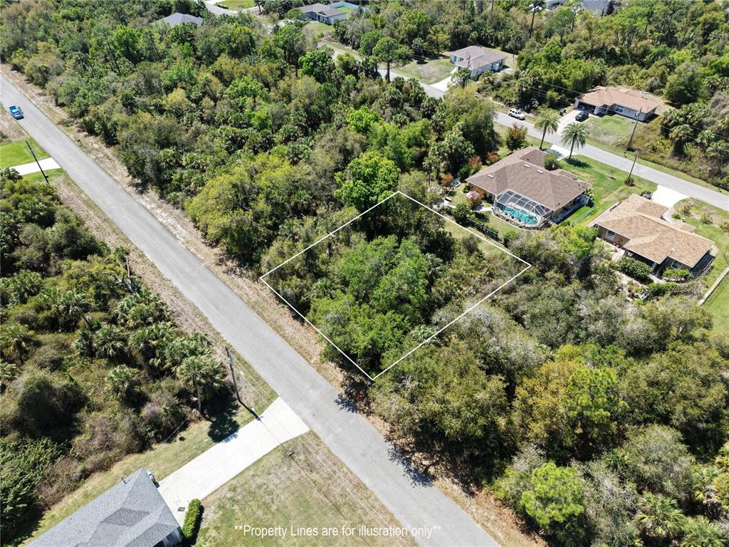 An aerial view shows a vacant, wooded residential lot outlined in white along a paved road — MCALLISTER LANE, NORTH PORT, FL