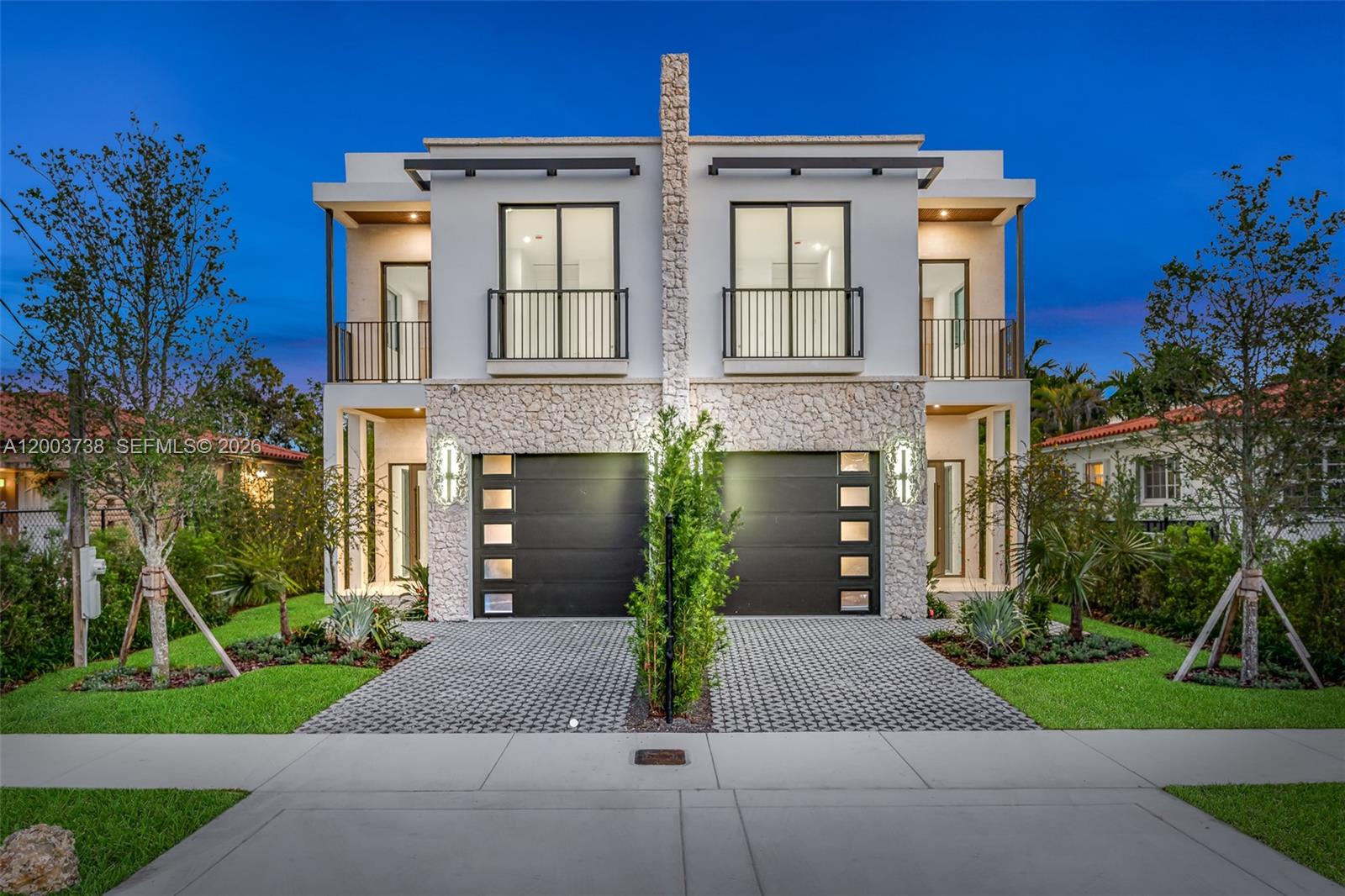 A modern two-story duplex with stone accents, two garages, and balconies at dusk — 3320 SW 23rd St, Miami FL 33145, MIAMI, FL