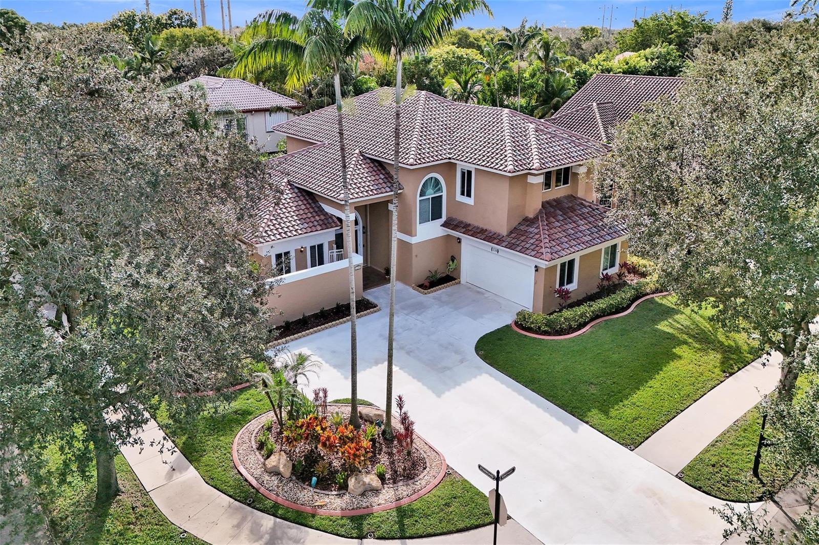 An aerial view of a two-story tan house with a tile roof and concrete driveway — 11300 Knot Way, Cooper City FL 33026, COOPER CITY, FL