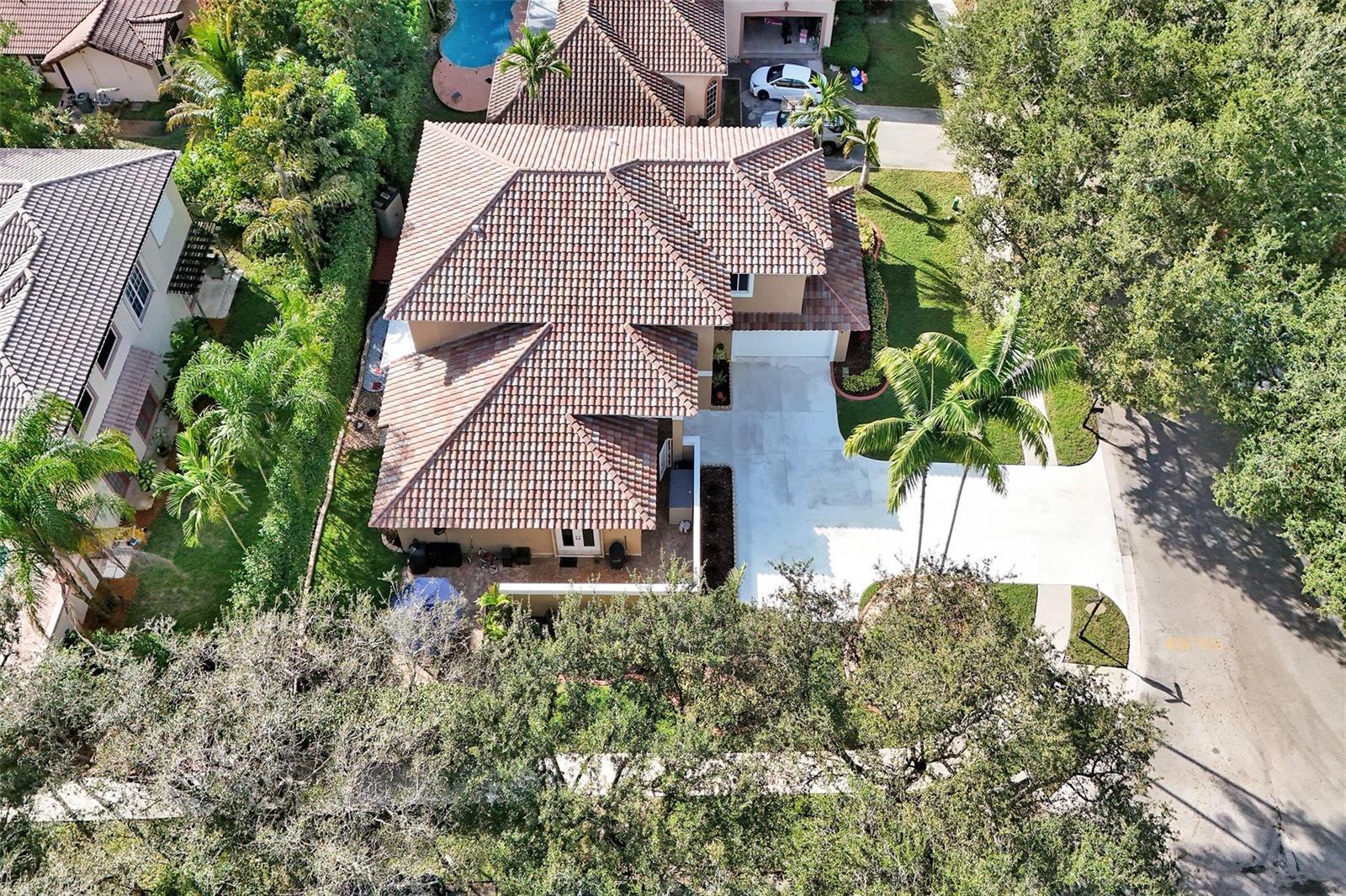 An aerial view shows a two-story house with a tiled roof, driveway, and surrounding trees — 11300 Knot Way, Cooper City FL 33026, COOPER CITY, FL