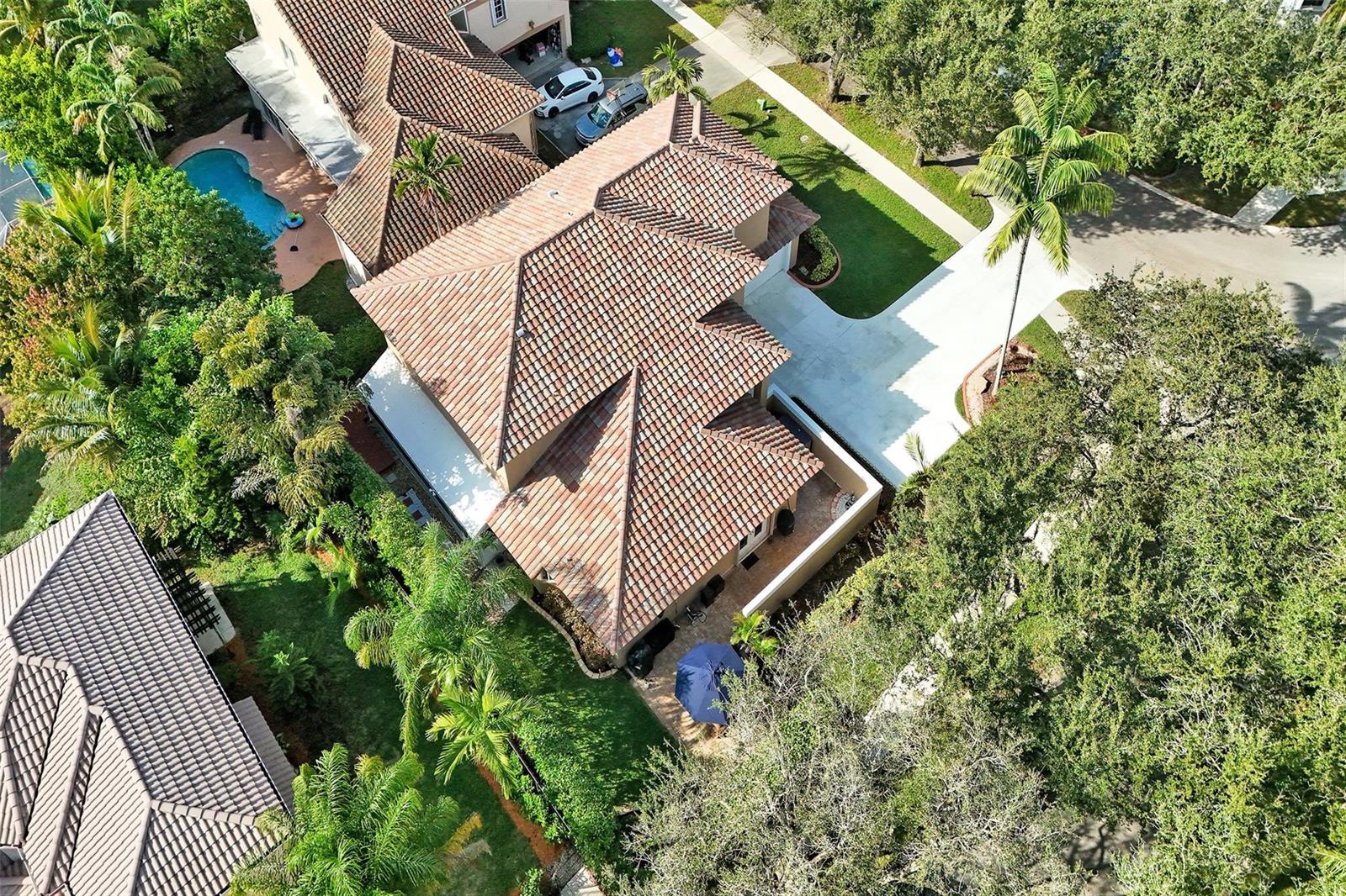 An aerial view shows a house with a tiled roof, a pool, and surrounding landscaping — 11300 Knot Way, Cooper City FL 33026, COOPER CITY, FL