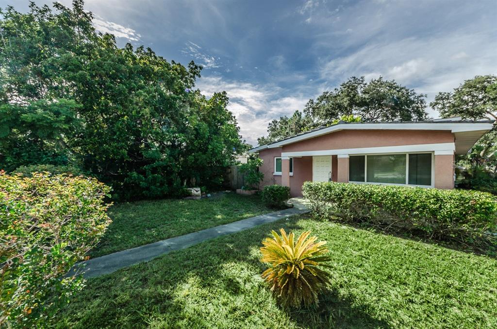 A single-story house with a pink exterior, a front walkway, and a landscaped yard — 5401 5TH AVENUE N, ST PETERSBURG, FL