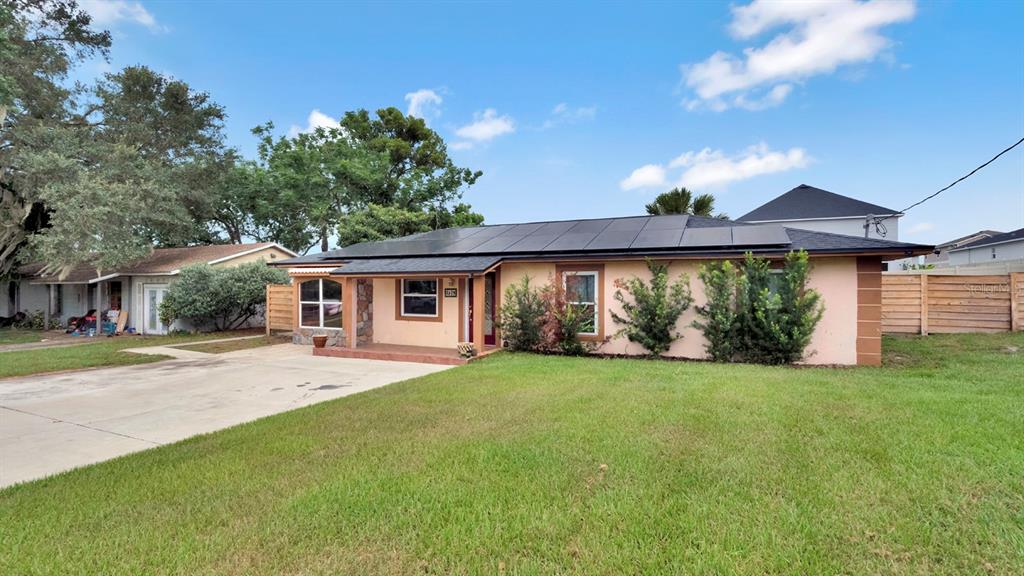 A single-story house with solar panels on the roof and a concrete driveway — 1426 ELLEN LANE, APOPKA, FL