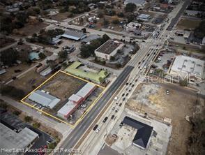 An aerial view shows a commercial property outlined in yellow along a busy road — 104 US 27 HIGHWAY S, AVON PARK, FL