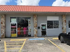The exterior of a commercial building features a red metal roof and stone-accented pillars — 104 US 27 HIGHWAY S, AVON PARK, FL