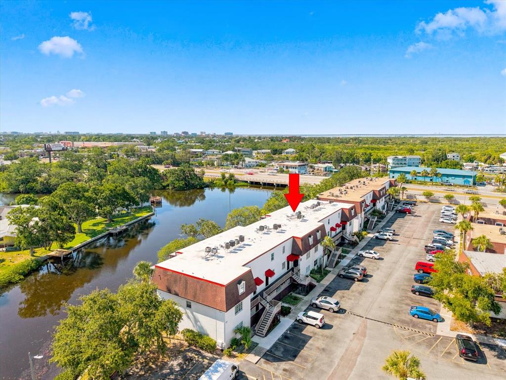 An aerial view shows a multi-story apartment building next to a canal and parking lot — 9009 TUDOR DRIVE UNIT G206, TAMPA, FL