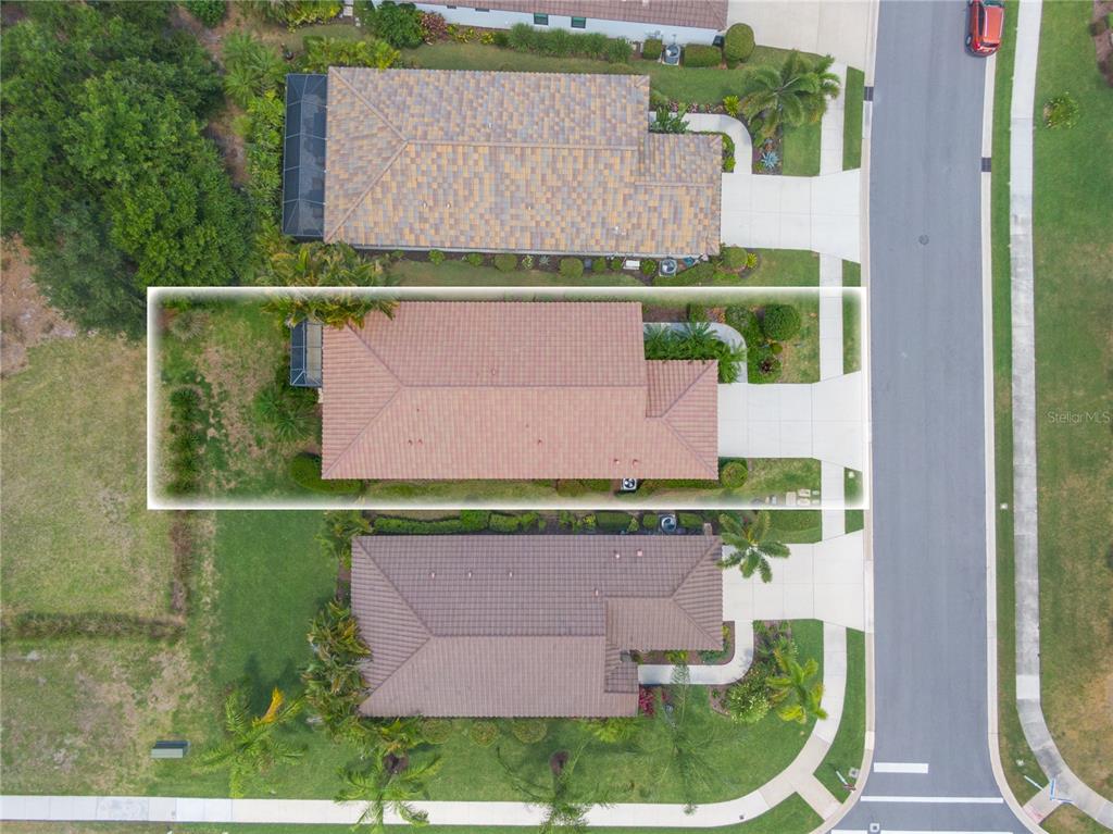 An aerial view shows a single-story house with a tiled roof and a backyard lawn — 4226 MIDNIGHT BLUE RUN, BRADENTON, FL