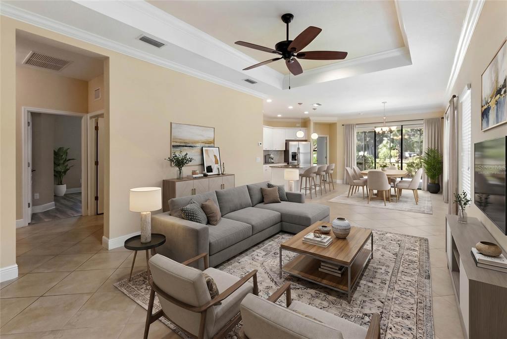 An open-concept living room and dining area with tile floors and a tray ceiling — 4226 MIDNIGHT BLUE RUN, BRADENTON, FL