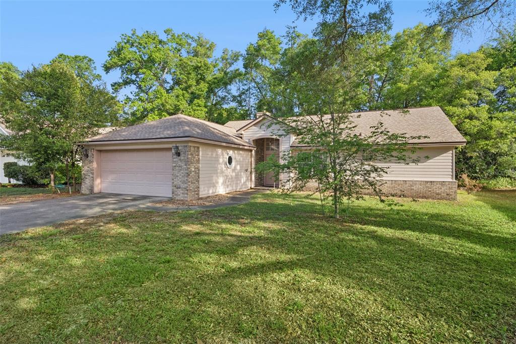 A single-story house with a two-car garage, brick accents, and a large front lawn — 1193 GLEN FALLS ROAD, DELAND, FL