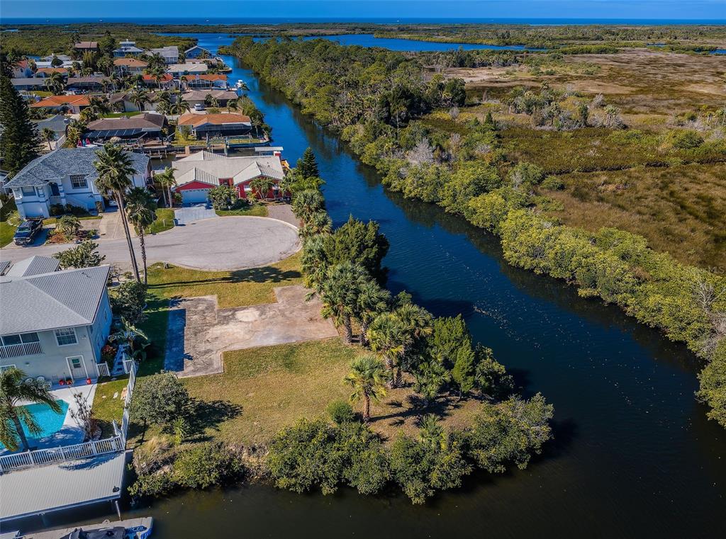 An aerial view shows a vacant waterfront lot next to a canal and residential homes — 0 SAN SIERRA WAY, PORT RICHEY, FL