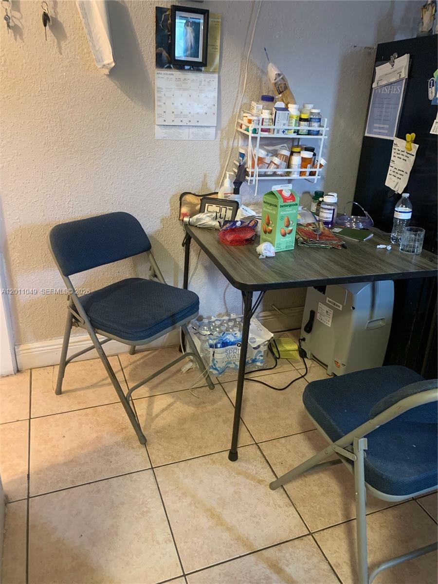 A small dining area features a folding table, two chairs, and a wall-mounted medicine shelf — 1495 SW 131st AVE, Miami FL 33184, MIAMI, FL