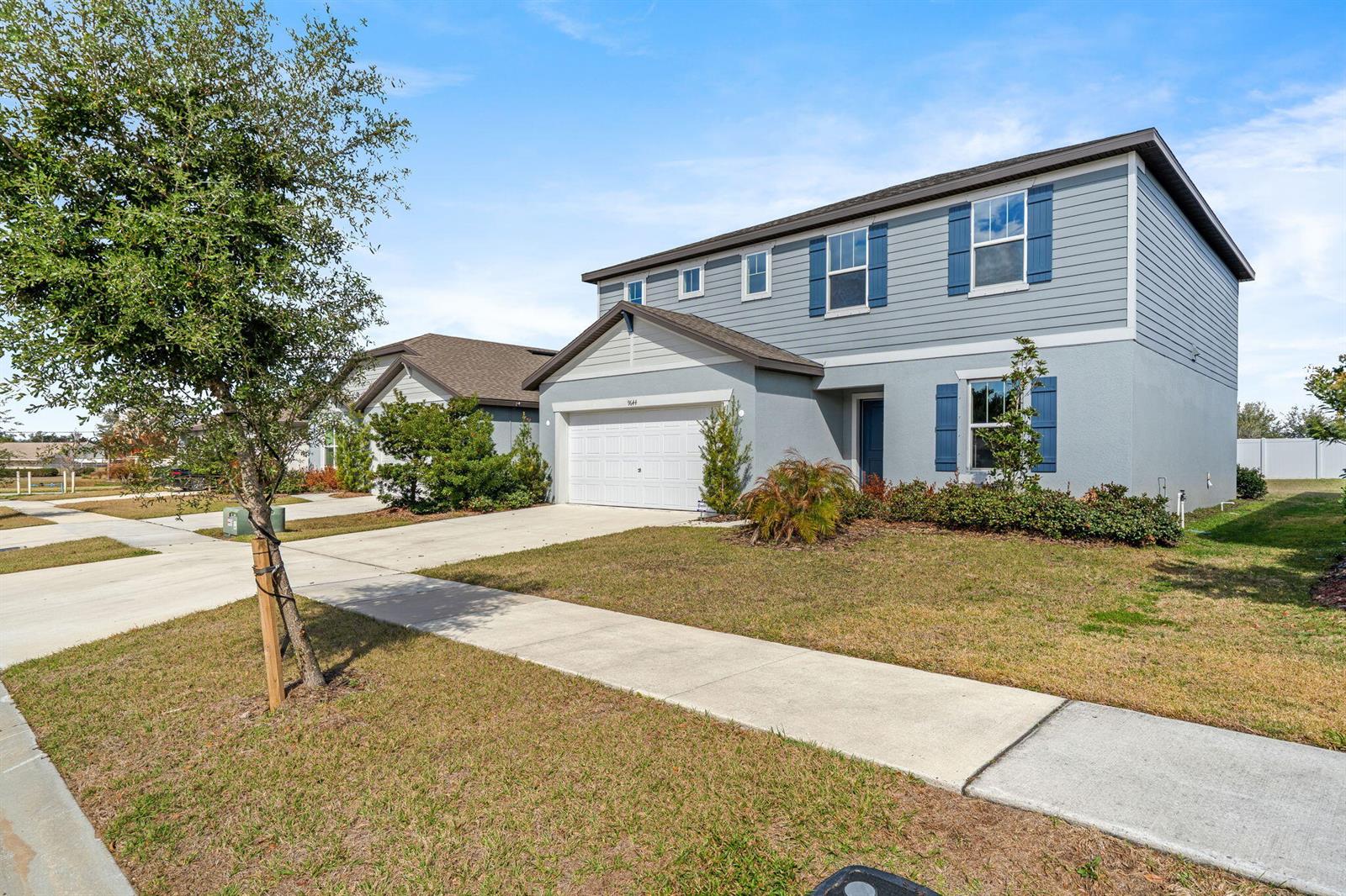A two-story house with a gray exterior, blue shutters, and a two-car garage — 9644 Summers Cay Circle, FL 33592, FL