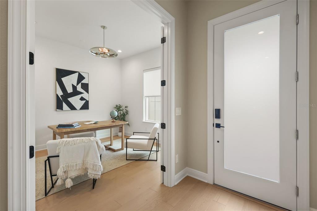 A home office with a wooden desk and modern decor is visible through double doors — 344 AMBERSWEET PLACE, LAKE MARY, FL