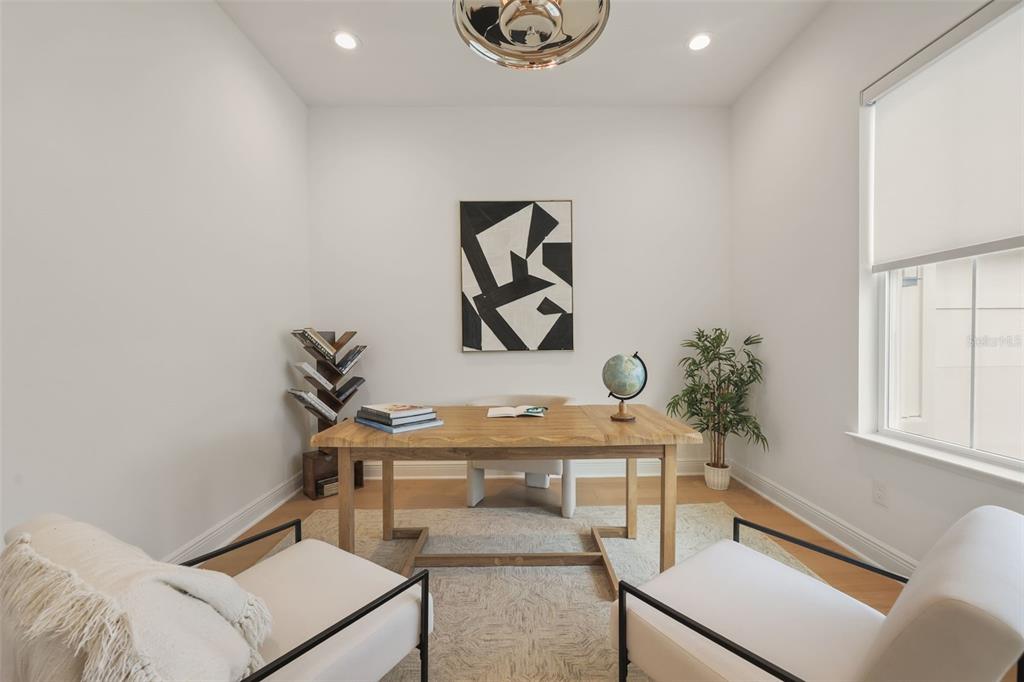 A home office features a wooden desk, two armchairs, a bookshelf, and abstract wall art — 344 AMBERSWEET PLACE, LAKE MARY, FL