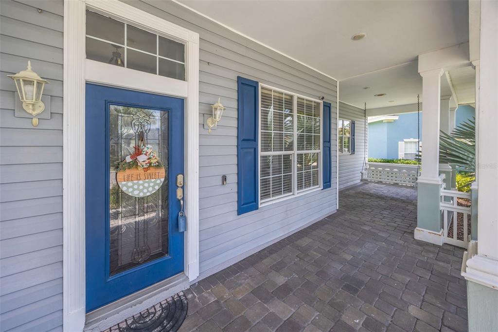 A blue front door with a glass insert and a covered porch with stone flooring — 4303 TOKOSE PLACE, LAKELAND, FL