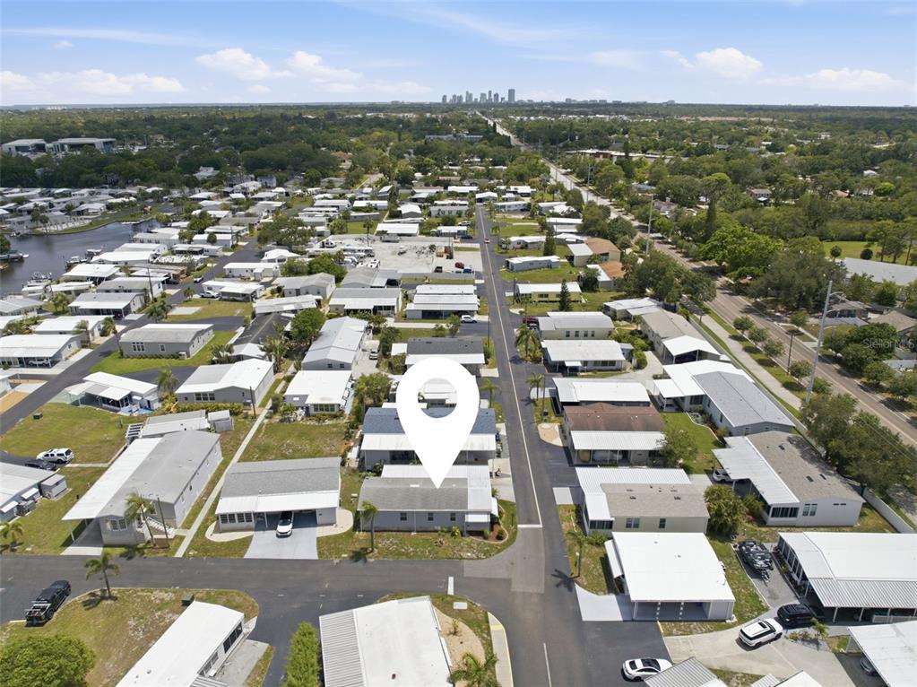 An aerial view shows a single-story house with a white location pin in a neighborhood — 6907 AMERICANA DRIVE NE UNIT 101, ST PETERSBURG, FL