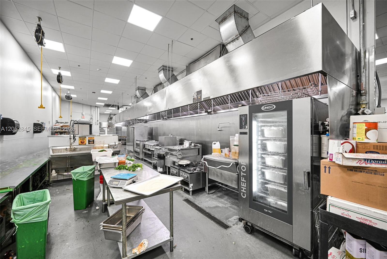 A commercial kitchen features stainless steel equipment, a large exhaust hood, and a convection oven — 1395 E 11th Ave, Hialeah FL 33010, HIALEAH, FL