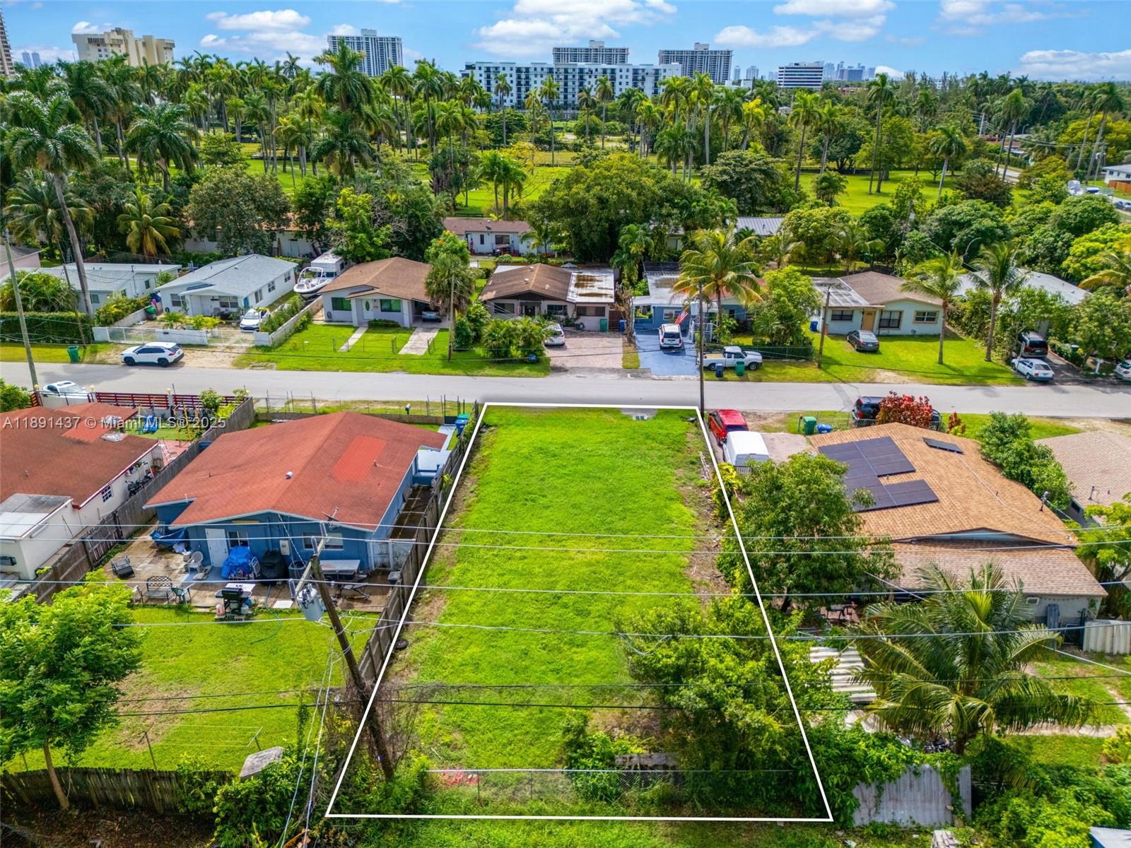 An aerial view shows a vacant rectangular residential lot situated between two existing houses — 1453 NE 117th St, Miami FL 33161, MIAMI, FL