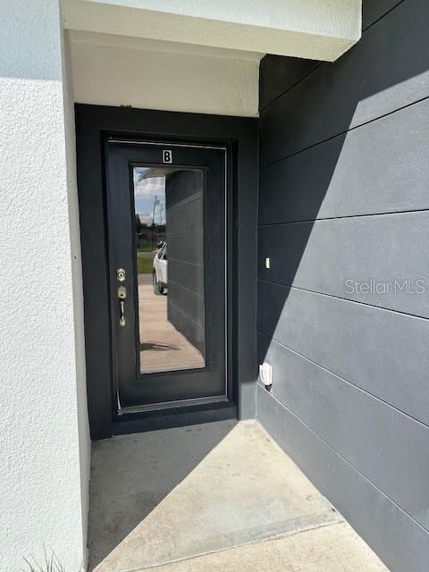 A black front door with a glass panel and a letter B sign — 542 KILIMANJARO, KISSIMMEE, FL