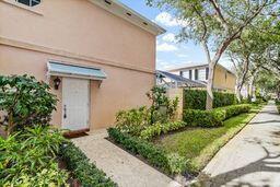 A tan two-story building exterior features a white front door with a metal awning — 3 Oakland Court, Tequesta FL 33469, TEQUESTA, FL