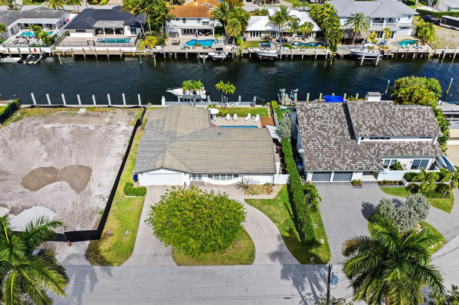 An aerial view shows two waterfront houses with pools and boat docks along a canal — 2821 NE 9th Court, Pompano Beach FL 33062, POMPANO BEACH, FL