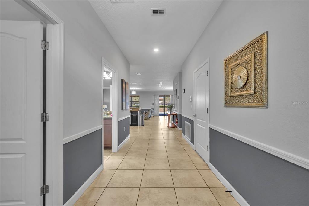 A tiled hallway leads to an open living area with gray walls and white trim — 1435 ROLLING FAIRWAY DRIVE, DAVENPORT, FL