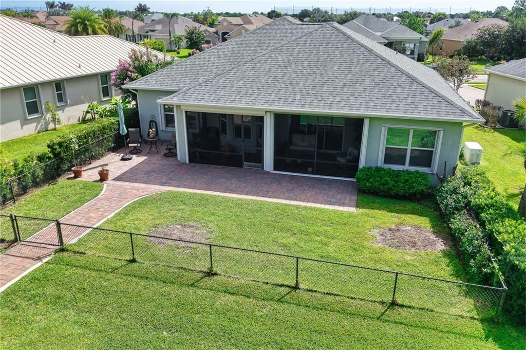 An aerial view of a house backyard featuring a screened-in patio and brick pavers — SEBASTIAN, FL