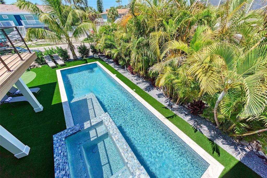 An elevated view of a rectangular swimming pool with an attached spa and artificial turf — 256 GLADIOLUS STREET, ANNA MARIA, FL