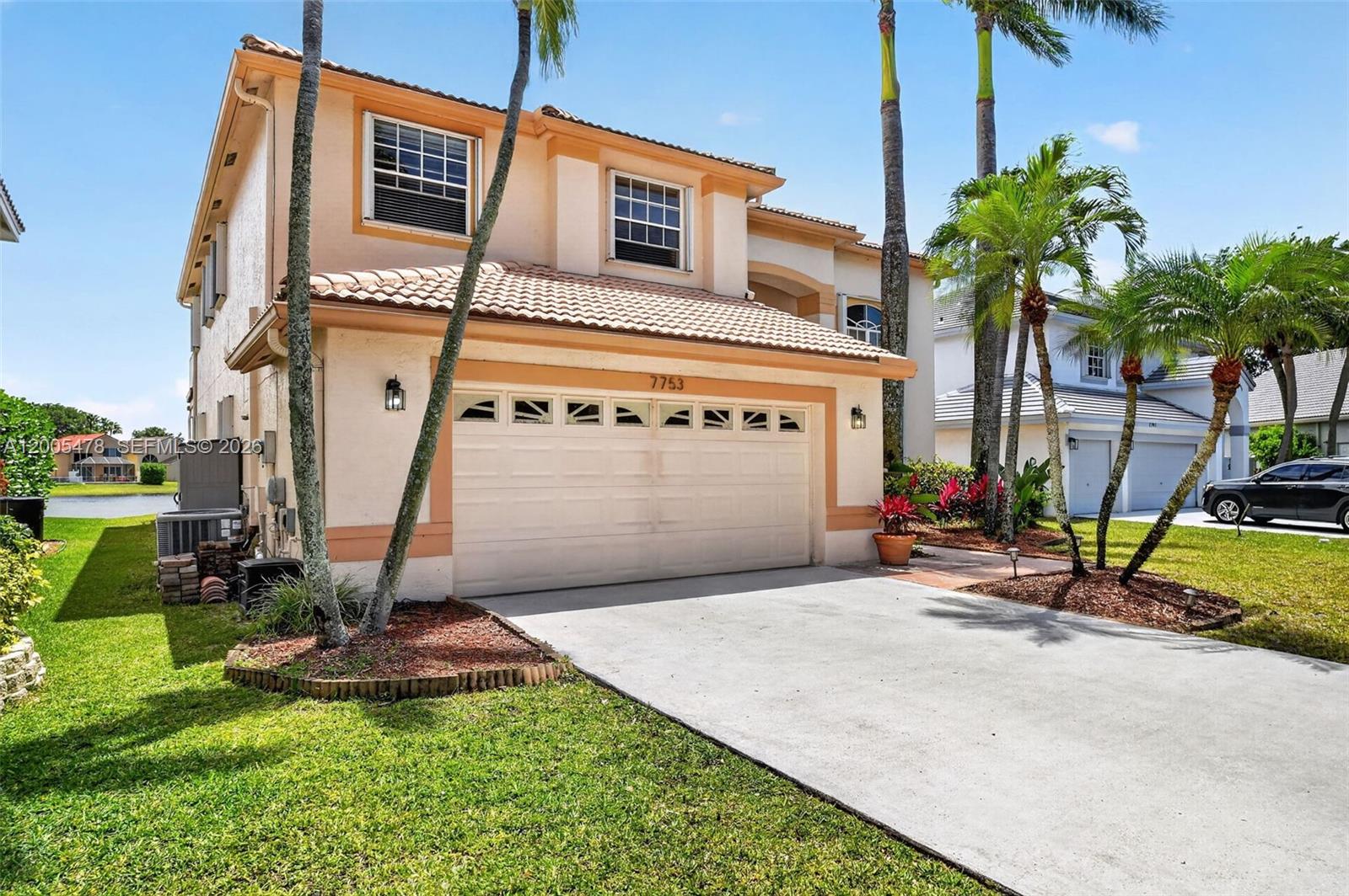 A two-story stucco house with a tiled roof, a two-car garage, and palm trees — 7753 Cedar Hurst Ct, Lake Worth FL 33467, LAKE WORTH, FL