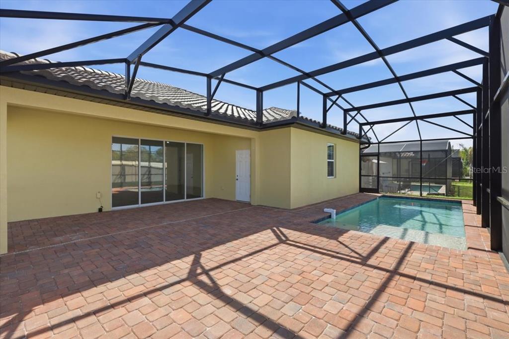 A screened-in patio features a brick paver floor and a small swimming pool — 363 VILLA SORRENTO CIRCLE, HAINES CITY, FL