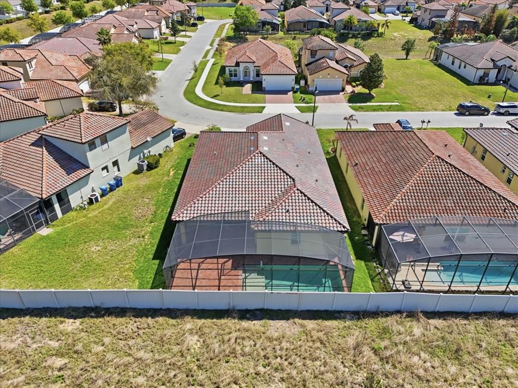 An aerial view shows a suburban neighborhood with houses featuring tiled roofs and screened-in pools — 363 VILLA SORRENTO CIRCLE, HAINES CITY, FL