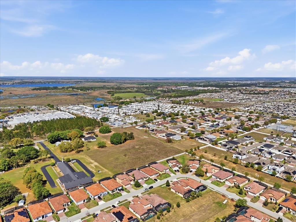 An aerial view shows a suburban neighborhood with houses, a mobile home park, and wetlands — 363 VILLA SORRENTO CIRCLE, HAINES CITY, FL