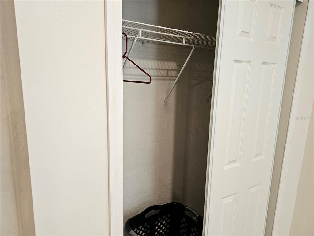 A small closet features a white wire shelf and a single hanger — 557 EAGLE COURT, KISSIMMEE, FL
