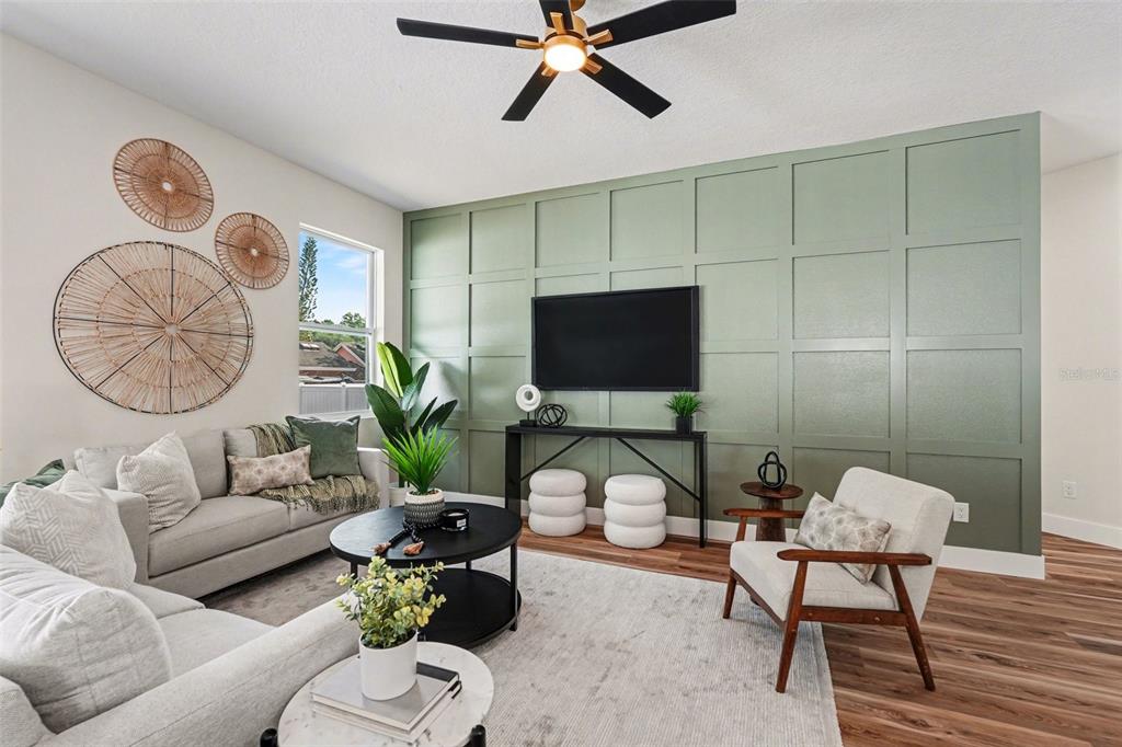 A living room features a sage green grid-paneled accent wall, a sofa, and an armchair — 1719 W PERIO STREET, TAMPA, FL