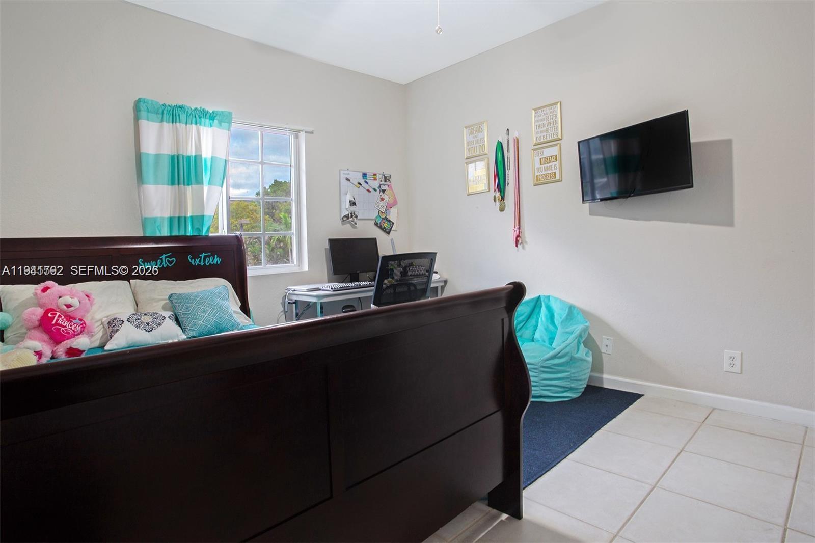 A bedroom features a dark wood bed, a desk, a television, and a beanbag chair — 911 Hillcrest Ct # 127, Hollywood FL 33021, HOLLYWOOD, FL