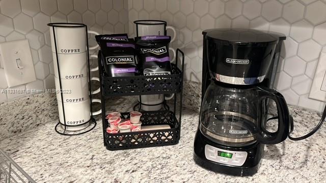 A black coffee maker sits on a granite countertop next to a coffee mug rack — 1247 S Newkirk, PA 19146, PA