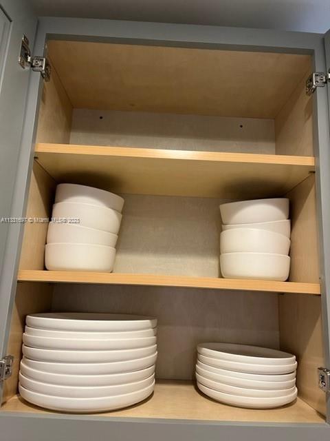 An open kitchen cabinet with two shelves containing stacks of white bowls and plates — 1247 S Newkirk, PA 19146, PA