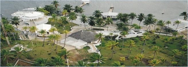 An aerial view shows a coastal property with white buildings, palm trees, and a dock — N-A Portobello, Colon, P 3306, P