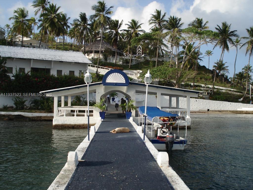 A long pier leads to a covered dock structure with a boat moored alongside — N-A Portobello, Colon, P 3306, P