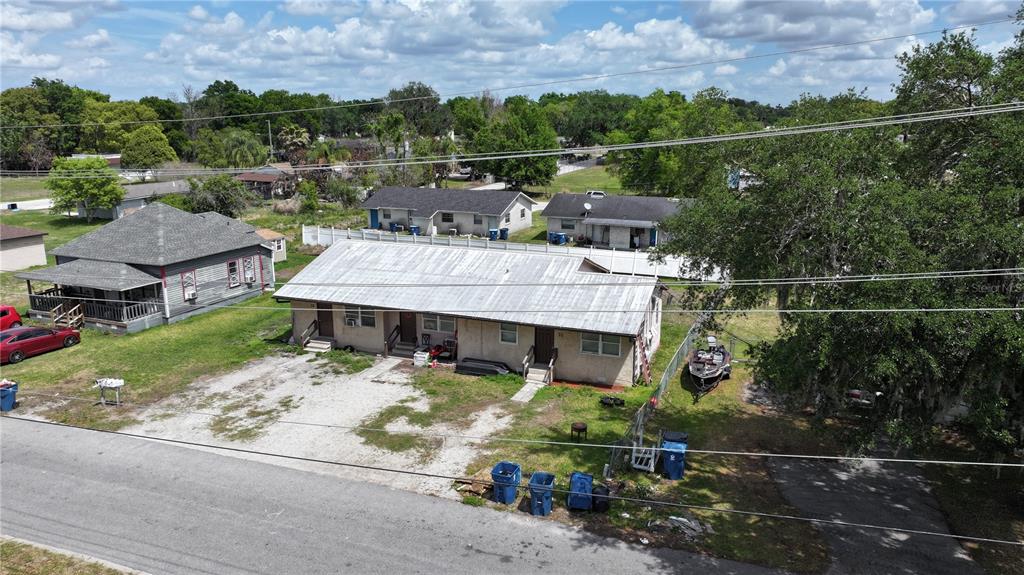 An aerial view shows a single-story multi-unit residential building with a metal roof — 32 N PALMETTO AVENUE, FORT MEADE, FL