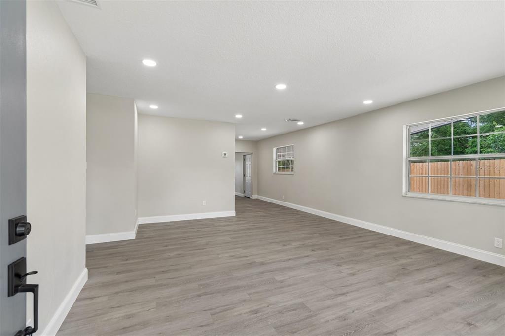 An empty living room features light gray walls, recessed lighting, and wood-look vinyl plank flooring — 6532 S WEST SHORE CIRCLE, TAMPA, FL