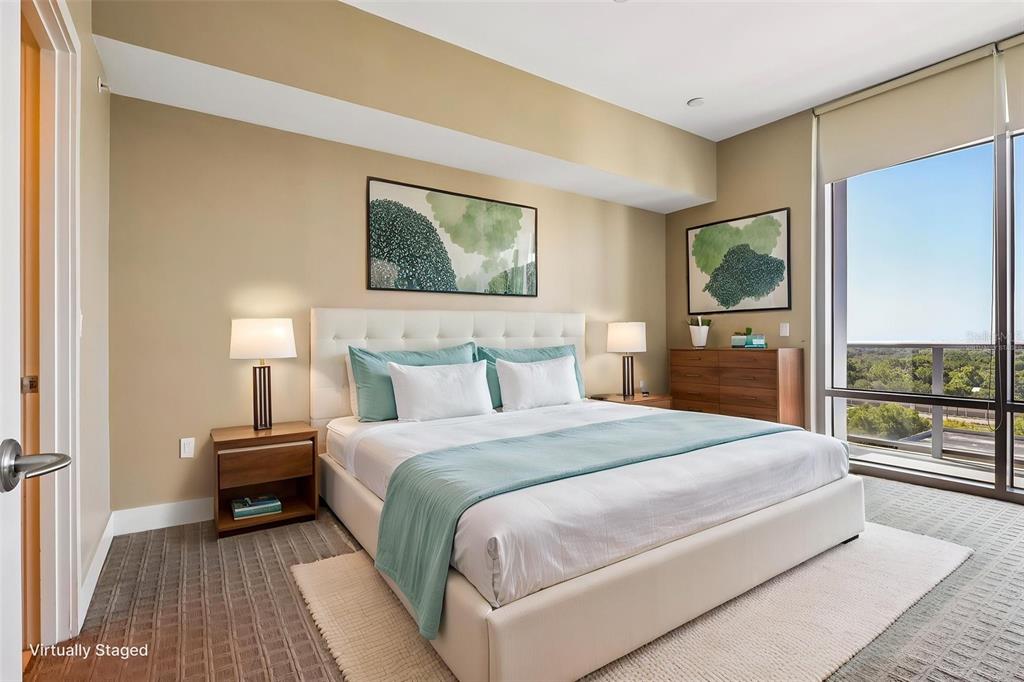A bedroom features a white upholstered bed, two nightstands, and a large window with views — 260 S OSCEOLA AVENUE UNIT 1005, ORLANDO, FL