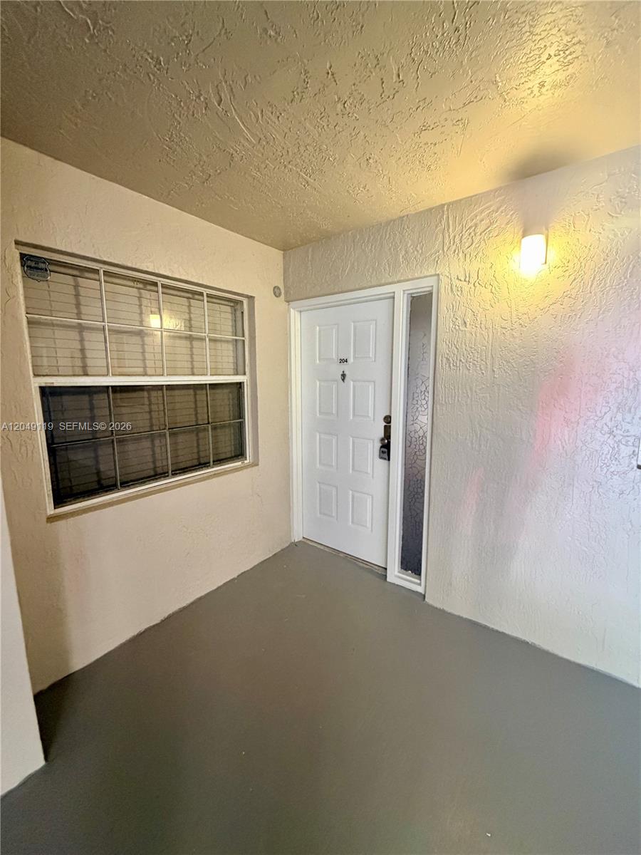 This is an exterior view of a residential entryway featuring a white door and window — OAKLAND PARK, FL
