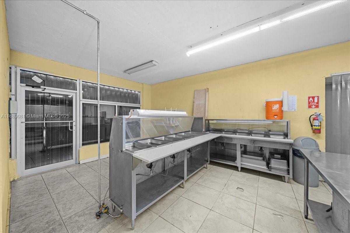 A commercial kitchen space features stainless steel food warmers, yellow walls, and tile flooring — 2313 NW 27th Ave, Miami FL 33142, MIAMI, FL